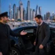Safe driver service cost in Dubai - professional chauffeur with luxury car at dusk